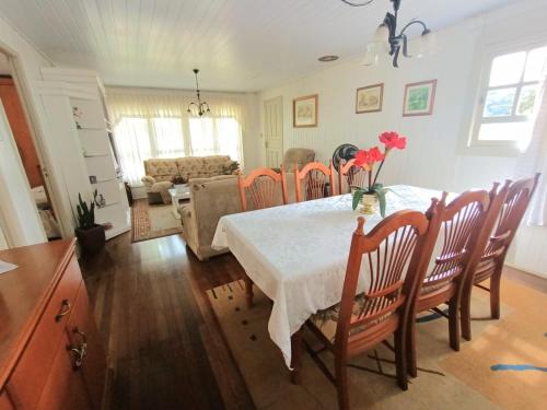 uma sala de jantar com mesa e cadeiras e uma sala de estar em Residencial Di Capri em Gramado