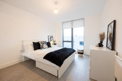 een witte slaapkamer met een bed en een raam bij Luxury 1Bed Apartment Central Location Manchester in Manchester