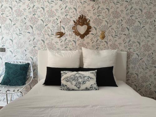 - un lit avec deux oreillers et un cœur sur un mur dans l'établissement Appartement du Cabaliros, à Argelès-Gazost