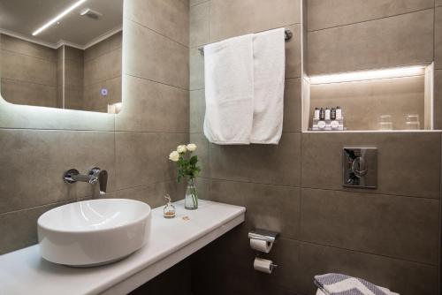 a bathroom with a white sink and a mirror at Parnassos Delphi Hotel in Delfoi