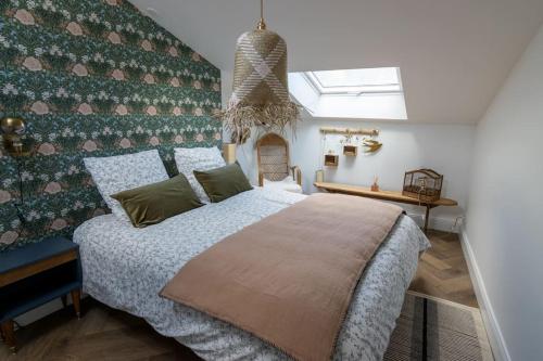 une chambre avec un grand lit et un mur dans l'établissement L'Instant D'Ambre - Parking - Centre - Clim, à Saumur