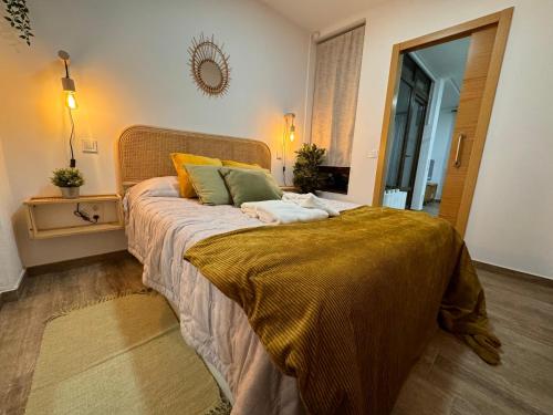 a bedroom with a large bed with yellow and green pillows at Suite con Cueva Romana/Roman Cave * Early Check-in in Toledo