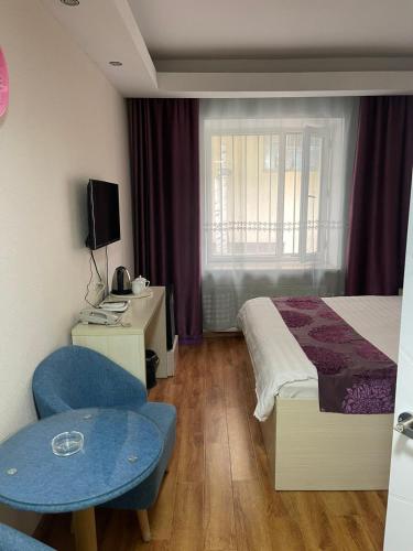 een hotelkamer met een bed en een tafel en stoelen bij Mandarin in Ulaanbaatar