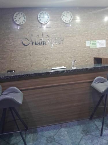 a counter with clocks on the wall and two chairs at Mandarin in Ulaanbaatar