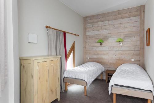 a room with two beds and a wooden wall at Résidence Le Christiana - maeva Home - Appartement Duplex 3 Pièces 10 Personnes - Sélection MAE-3643 in Saint-Bon-Tarentaise