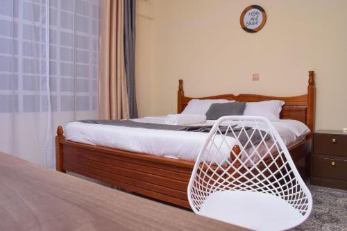 1 dormitorio con 1 cama con silla de mimbre blanca en Saas Homestay en Eldoret