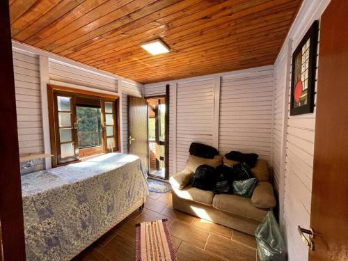 a bedroom with a bed and a couch in a room at Chácara em Ibiúna com piscina e acesso a represa in Ibiúna