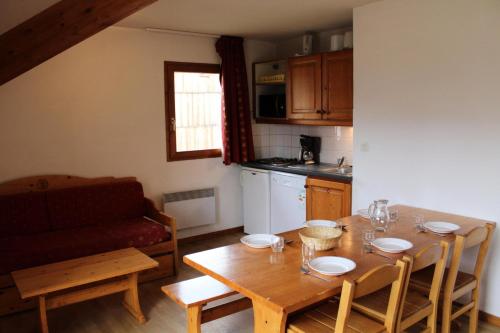 a kitchen with a wooden table and a dining room at Les Chalets De Superd Ancolie - 3 Pièces pour 10 Personnes 324 in Le Dévoluy