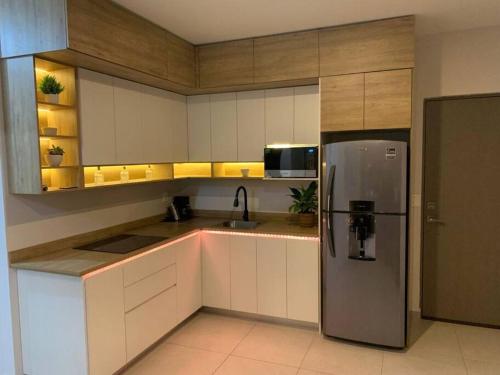 a kitchen with white cabinets and a refrigerator at Departamento Arena Vive in Monterrey