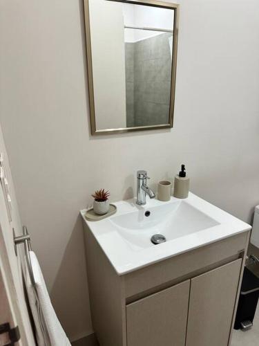 a bathroom with a white sink and a mirror at Departamento Arena Vive in Monterrey