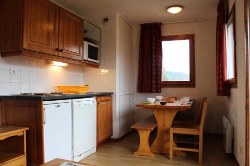 - une petite cuisine avec une table et une table dans l'établissement Les Chalets De Superd Ancolie - APPARTEMENT DANS CHALET DE 30 LOGEMENTS EXPO VALLEE MAE-8434, à Saint-Étienne-en-Dévoluy