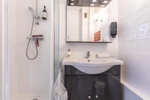 a white bathroom with a sink and a shower at Cosy T1 Lavoisier tout équipée avec balcon CL-FD in Clermont-Ferrand