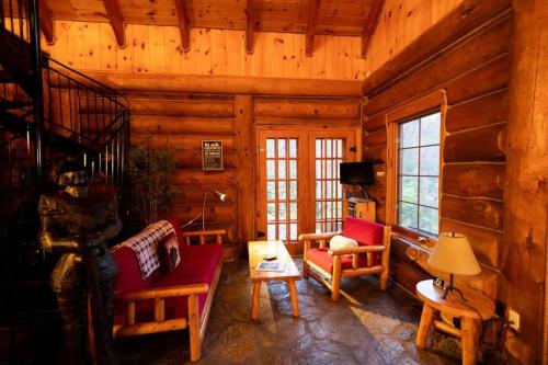 uma sala de estar de um chalé de madeira com paredes de madeira em Bois Rond Sauna Lake em Grenville-sur-la-Rouge