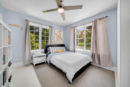 sypialnia z łóżkiem i 2 oknami w obiekcie Oceanfront Elegance: 3-BR Villa in Miami's Design w Miami