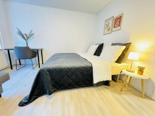 a bedroom with a bed and a table and a chair at aday - Awesome Central ground floor apartment in Aalborg