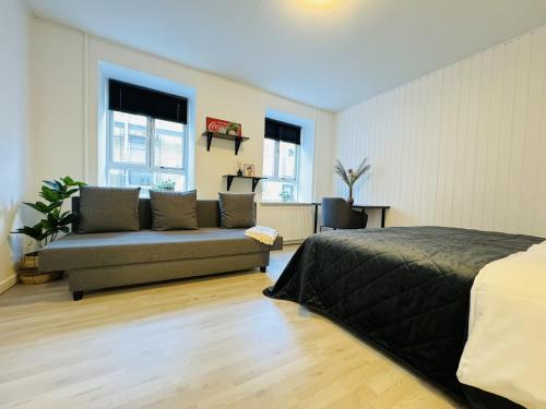 a bedroom with a bed and a couch in a room at aday - Awesome Central ground floor apartment in Aalborg