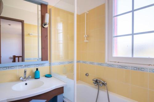une salle de bain avec un lavabo, une baignoire et un miroir dans l'établissement Les Maisons de Port Bourgenay - maeva Home - Maison 3 Pièces 6 Personnes - Sélection MAE-5504, à Talmont-Saint-Hilaire