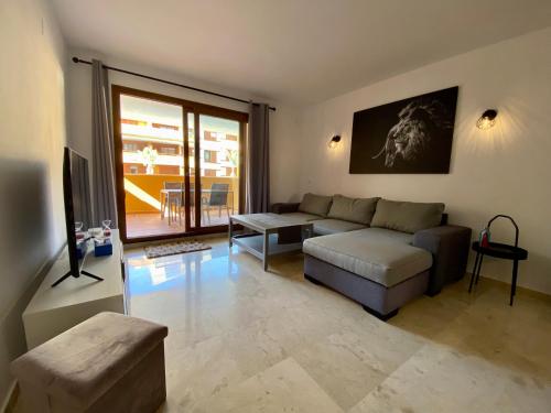 un soggiorno con un divano e un tavolo di Apartamento con piscina y playa cercana en Torrevieja, area de Punta Prima AQ-125 a Punta Prima