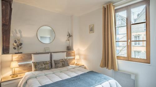 a bedroom with a bed with a mirror and a window at Le Logis des Perles 1 - Emplacement Idéal - 4 pers in Troyes