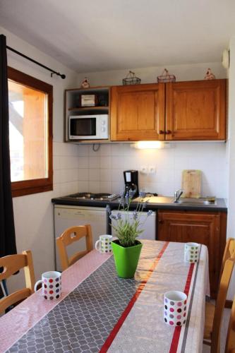 une cuisine avec une table et une cuisine avec une table dans l'établissement Les Chalets De Superd Heliantheme - 2 Pièces pour 6 Personnes MAE-8484, à Saint-Étienne-en-Dévoluy