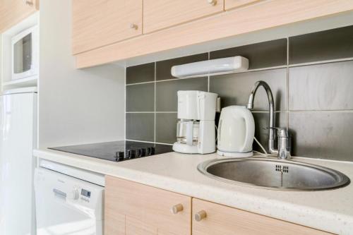 - un comptoir de cuisine avec évier et appareil dans l'établissement Résidence Port Bourgenay - maeva Home - Appartement 2 Pièces 6 Personnes - Sélection MAE-5473, à Talmont-Saint-Hilaire