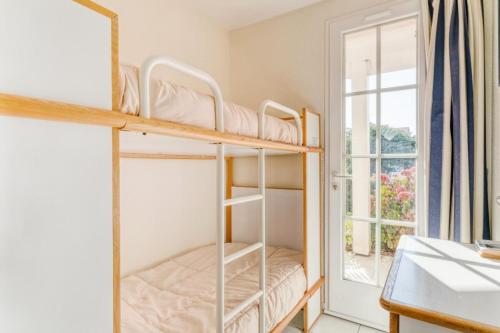 une chambre avec deux lits superposés et une fenêtre dans l'établissement Résidence Port Bourgenay - maeva Home - Appartement 2 Pièces 6 Personnes - Sélection MAE-5473, à Talmont-Saint-Hilaire