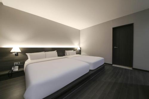 Ein Bett oder Betten in einem Zimmer der Unterkunft H Avenue Hotel Sangmu Branch