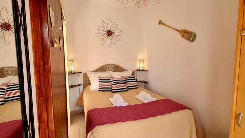 małą sypialnię z łóżkiem i kapciami w obiekcie Appartement Kallisté, Logements avec vue citadelle de Bonifacio w mieście Bonifacio