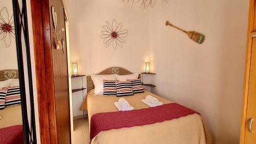une petite chambre avec un lit avec des pantoufles dessus dans l'établissement Appartement Kallisté, Logements avec vue citadelle de Bonifacio, à Bonifacio