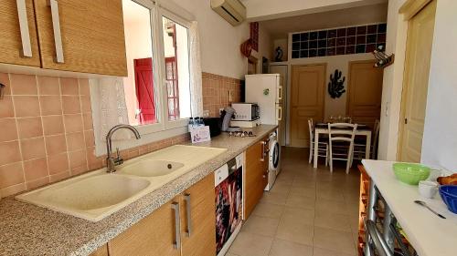 une cuisine avec un évier et un comptoir dans l'établissement Appartement Kallisté, Logements avec vue citadelle de Bonifacio, à Bonifacio