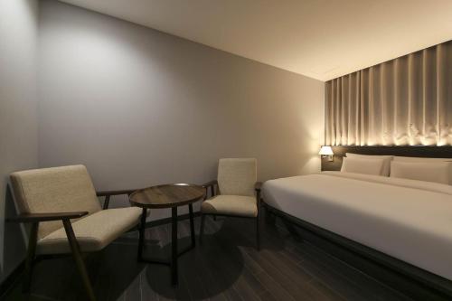 Ein Bett oder Betten in einem Zimmer der Unterkunft H Avenue Hotel Sangmu Branch