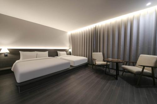 Ein Bett oder Betten in einem Zimmer der Unterkunft H Avenue Hotel Sangmu Branch