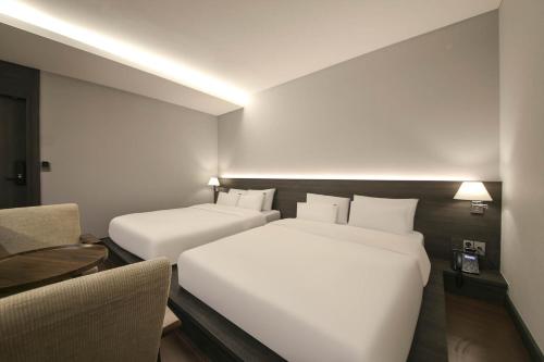 Ein Bett oder Betten in einem Zimmer der Unterkunft H Avenue Hotel Sangmu Branch
