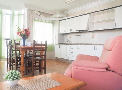 sala de estar con sofá rosa y mesa en ConilPlus apartments AZORIN II, en Conil de la Frontera