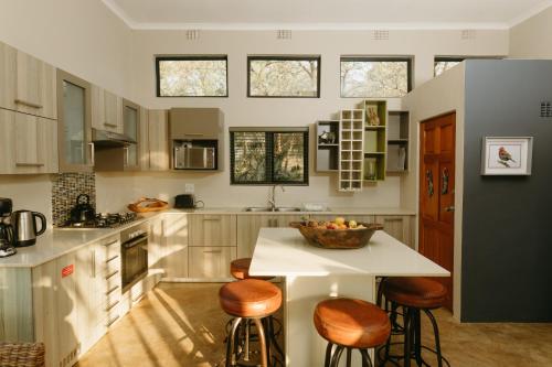 a kitchen with a table and stools in it at Sensiri Plains Safari Lodge in Mkuze