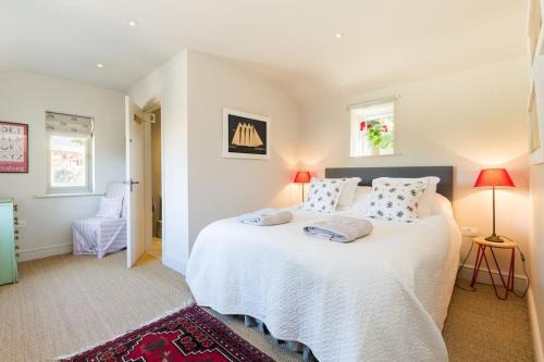 um quarto com uma grande cama branca e 2 almofadas em Charming Cottage surrounded by Idyllic garden in peaceful location in central Charlbury em Charlbury