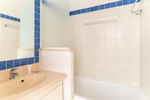 une salle de bain avec un lavabo, une baignoire et une douche dans l'établissement Résidence Bleu Marine - maeva Home - Appartement 2 pièces 4 personnes - Confort MAE-5880, à Lacanau