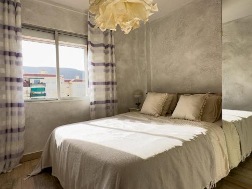 a bedroom with a bed with a large window at Amazing 3-bedroom apartment. Pool and sea view! in Los Cristianos