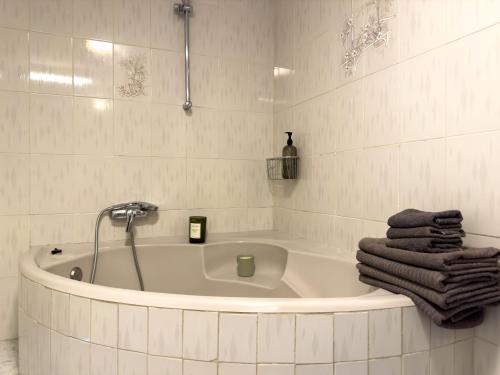 a white bathroom with a bath tub with towels at Amazing 3-bedroom apartment. Pool and sea view! in Los Cristianos