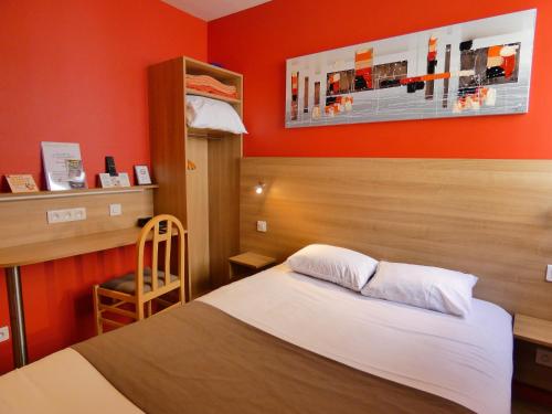 a bedroom with a bed with an orange wall at Logis Hôtel La Résidence, Cognac Centre in Cognac