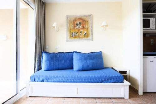 - un lit avec des oreillers bleus dans l'établissement Résidence le Hameau des Issambres - maeva Home - 2 Pièces 5 Personnes Sélection MAE-5850, aux Issambres