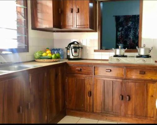 uma cozinha com armários de madeira e uma taça de fruta em Mambo & Jambo House em Mwanza