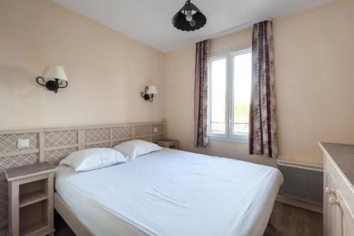 une chambre avec un lit blanc et une fenêtre dans l'établissement Les Coteaux de Pont Royal en Provence - maeva Home - Maison 4 Pièces 8 Personnes - Budget MAE-6009, à Mallemort