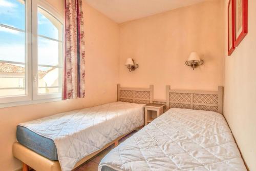 deux lits dans une chambre avec une fenêtre dans l'établissement Les Coteaux de Pont Royal en Provence - maeva Home - Appartement 3 Pièces 6 Personnes - Sélection MAE-5989, à Mallemort