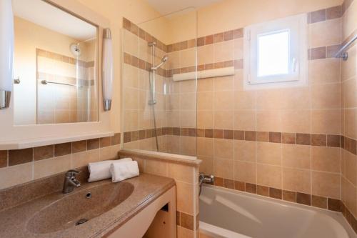 une salle de bain avec un lavabo, une baignoire et un miroir dans l'établissement Les Coteaux de Pont Royal en Provence - maeva Home - Appartement 2 Pièces 4 Personnes - Sélection MAE-5991, à Mallemort