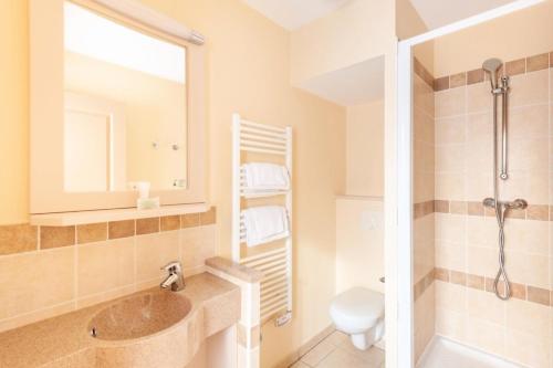 łazienka z umywalką, toaletą i lustrem w obiekcie Les Coteaux de Pont Royal en Provence - maeva Home - Maison 4 Pièces 8 Personnes - Sélection MAE-6026 w mieście Mallemort