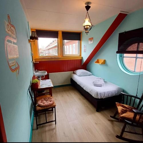 a small room with a bed and a staircase at Stee in Stad in Groningen