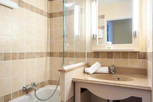 uma casa de banho com um lavatório e um chuveiro em Les Coteaux de Pont Royal en Provence - maeva Home - Maison 3 Pièces 6 Perso 13 em Mallemort