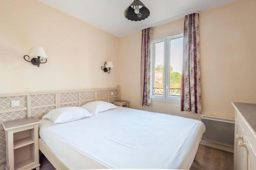 une chambre avec un lit blanc et une fenêtre dans l'établissement Les Coteaux de Pont Royal en Provence - maeva Home - Maison 4 Pièces 8 Personnes - Sélection MAE-6014, à Mallemort