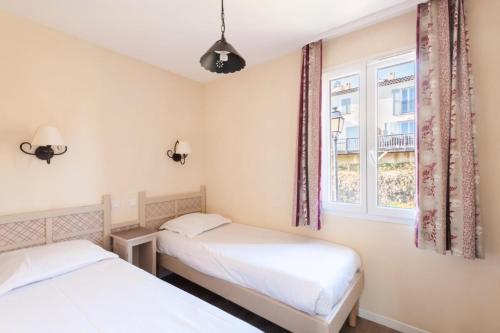 deux lits dans une chambre avec une fenêtre dans l'établissement Les Coteaux de Pont Royal en Provence - maeva Home - Maison climatisée 3 Pièces 6 Personnes - Sélection MAE-6027, à Mallemort